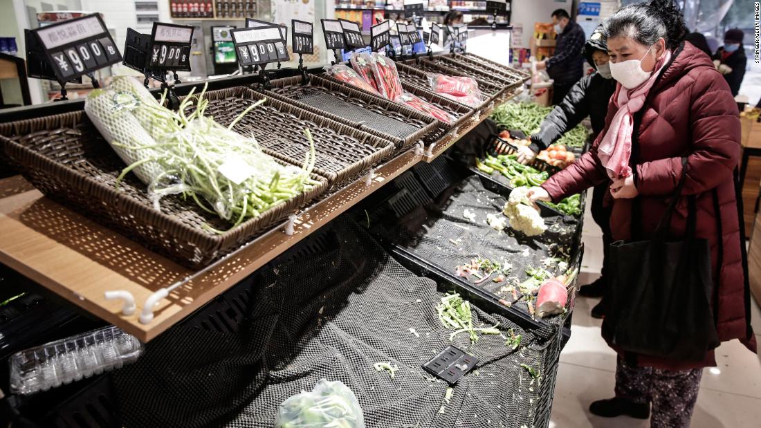 People wear masks while shopping for vegetables in Wuhan on January 23.